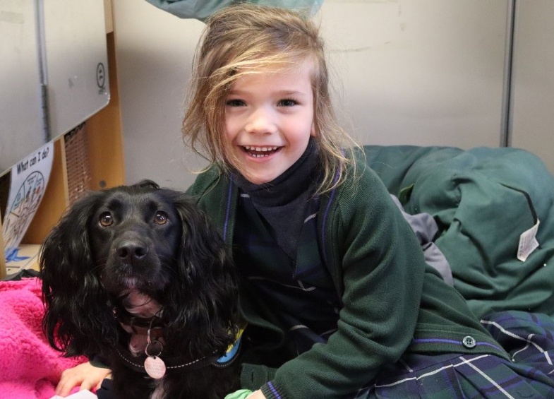 Girl hugs new nurture dog Luna who helps with pastoral care and wellbeing at Heath Mount